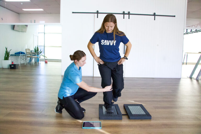 Exercise physiologist at SAVVY doing a run strength assessment on a client